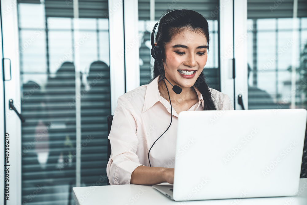 Businesswoman wearing headset working actively in office . Call center, telemarketing, customer supp