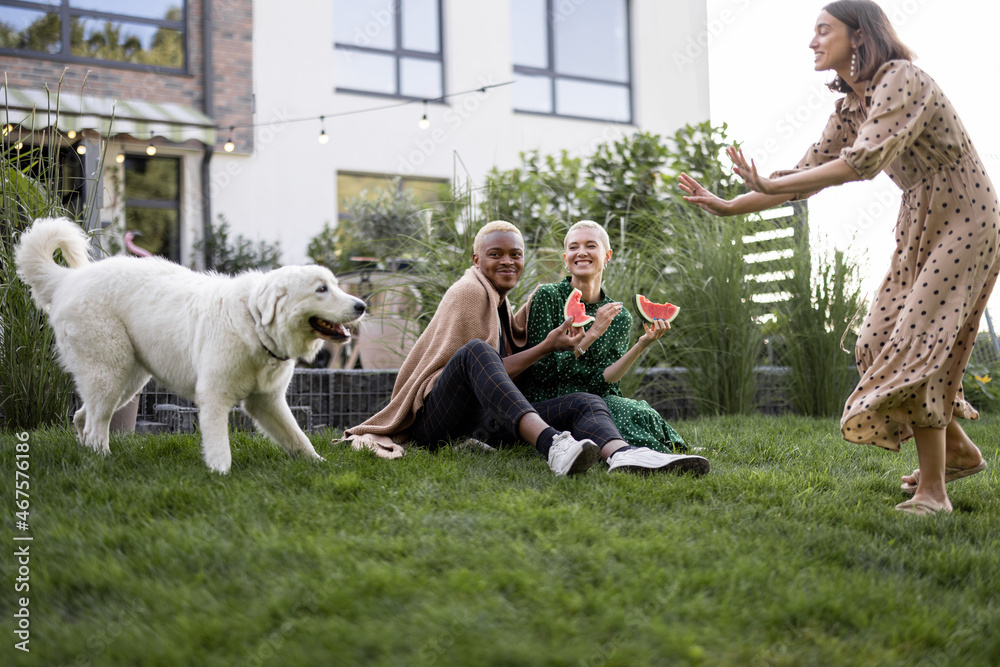 Multiracial couple eating watermelon in their garden. Concept of relationship and enjoying time toge