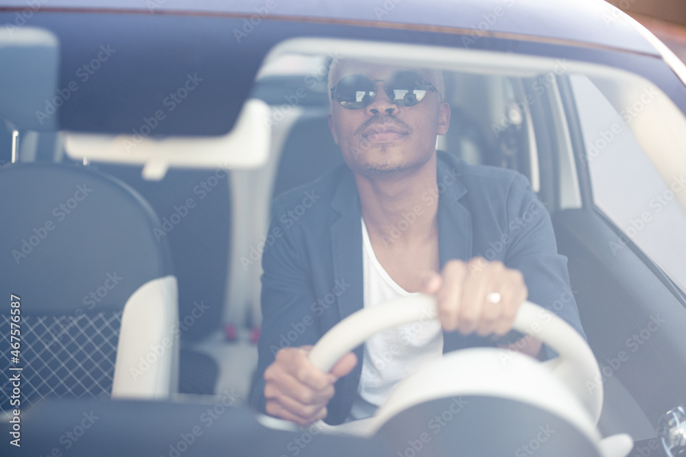 Latin man dressed in business wear drives his white car. Concentrated businessman at the driver seat