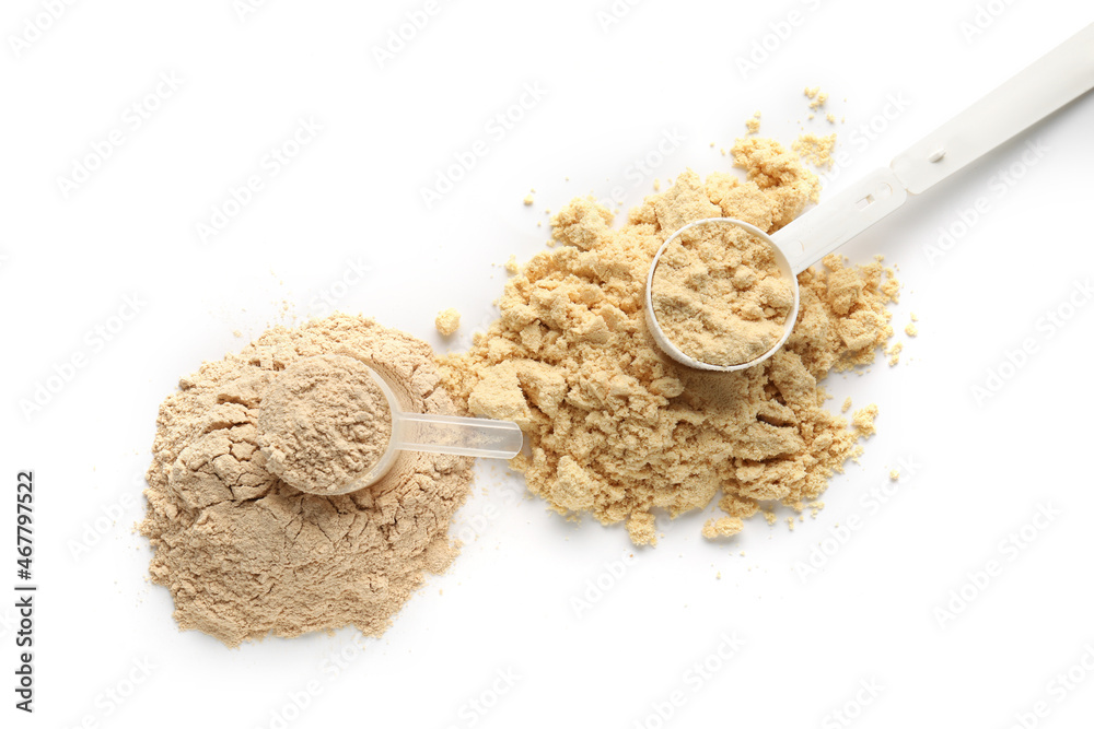 Measuring scoops with protein powder on white background