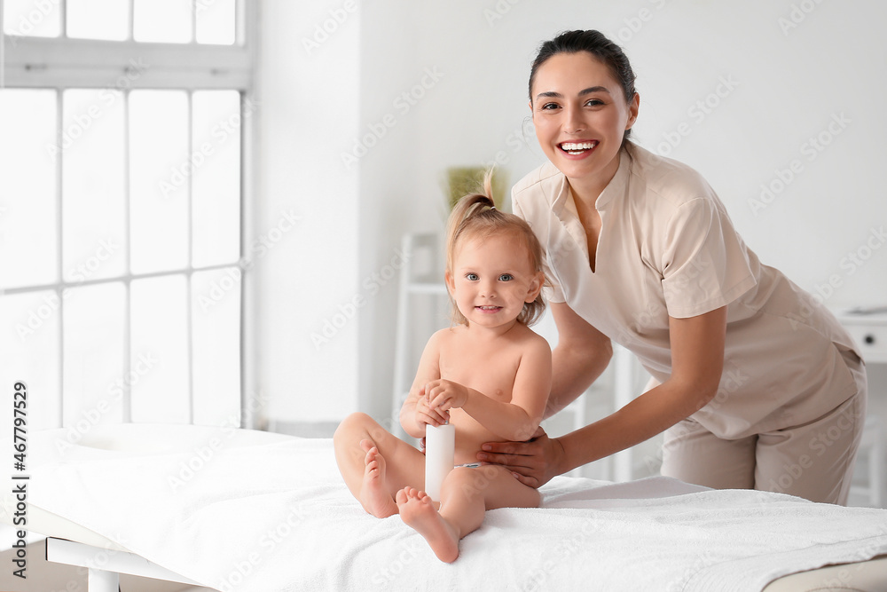 Massage therapist working with baby in medical center