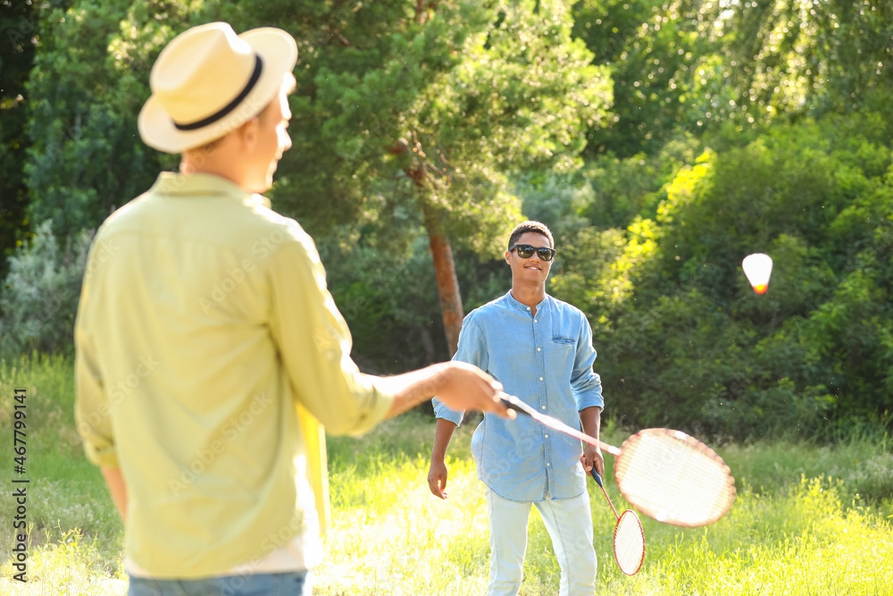 Young men playing badminton  outdoors