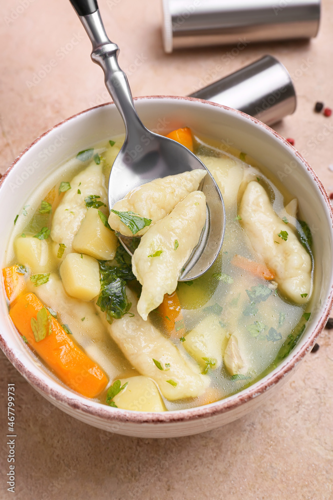 Bowl with delicious dumpling soup on color background, closeup