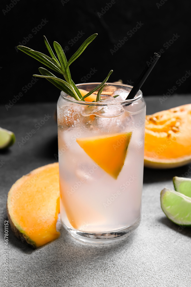 Glass of tasty melon cocktail on dark background