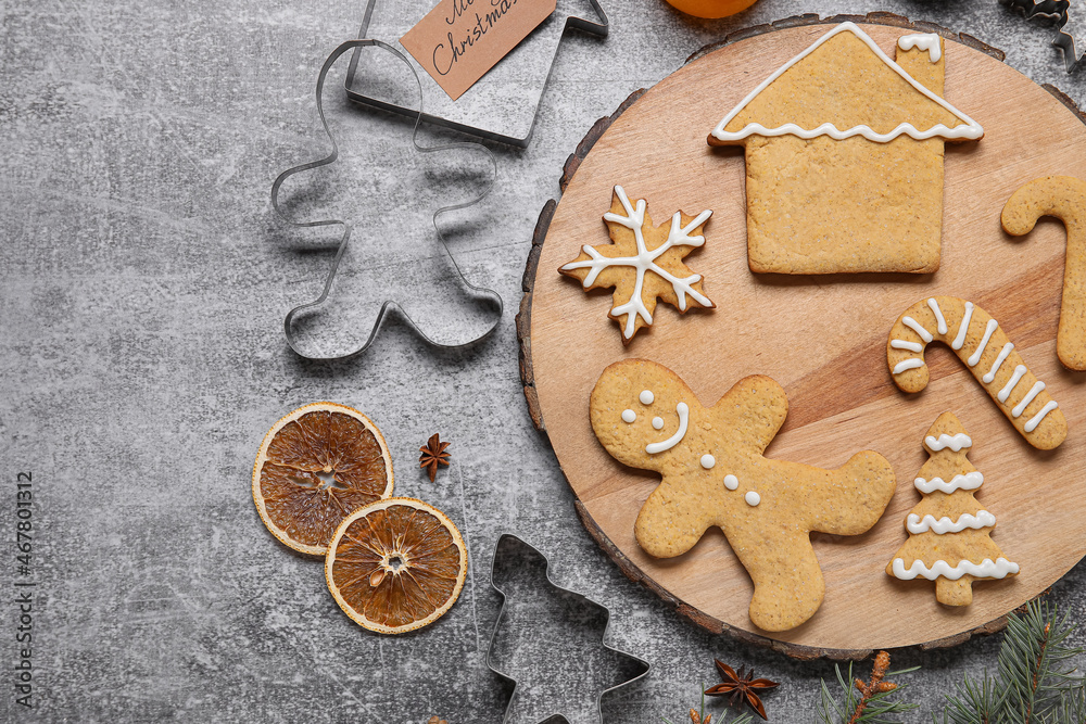 Board with Christmas gingerbread cookies and spices on grey background