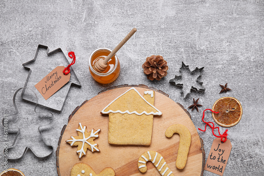 Board with Christmas gingerbread cookies, honey and spices on grey background