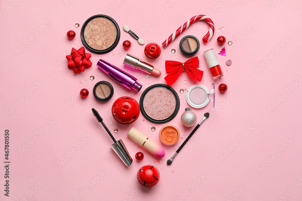 Heart made of makeup cosmetics and beautiful Christmas decor on color background