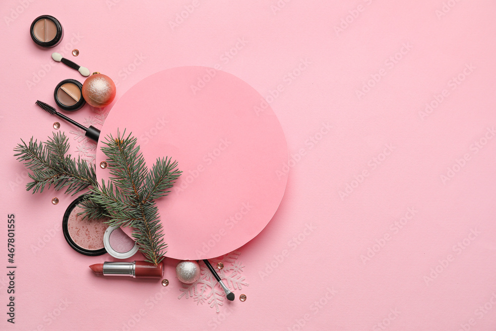 Composition with makeup cosmetics and fir branches on pink background