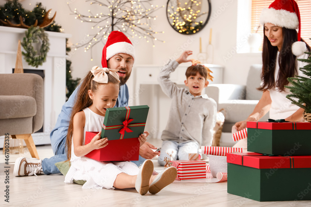 Cute little girl opening Christmas gift box at home