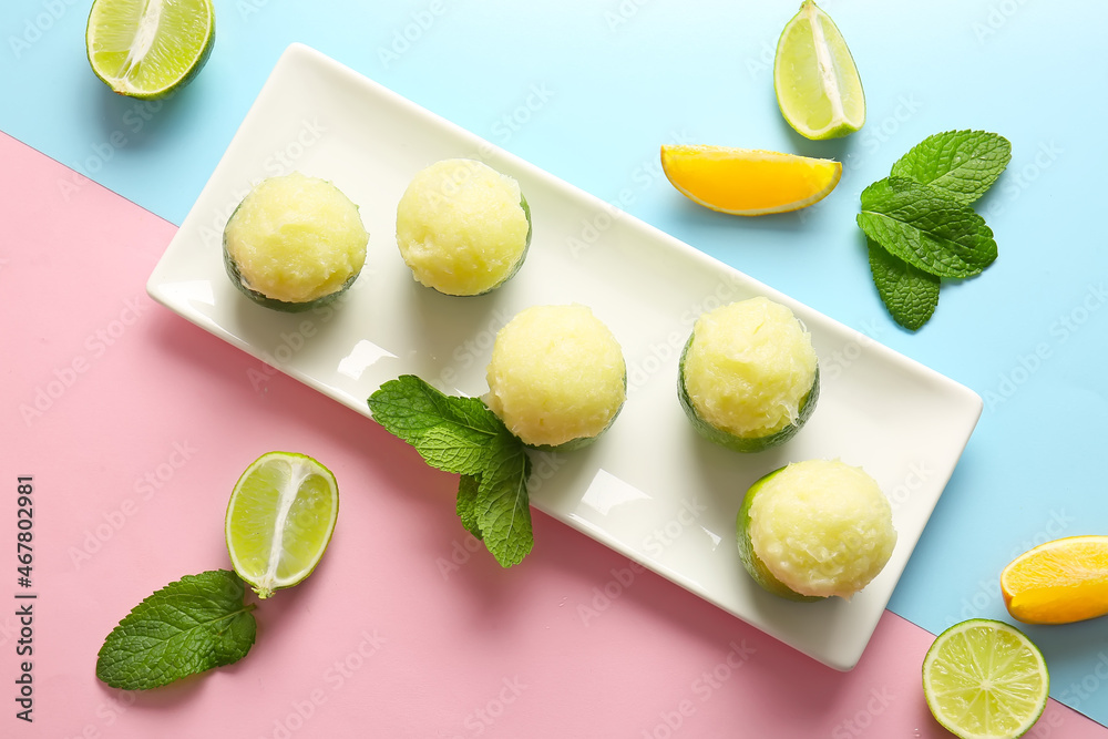 Plate with tasty ice creams in lime peels on color background