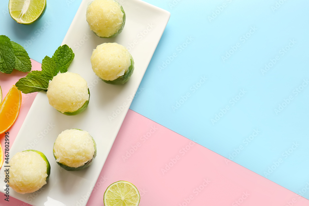 Plate with tasty ice creams in lime peels on color background