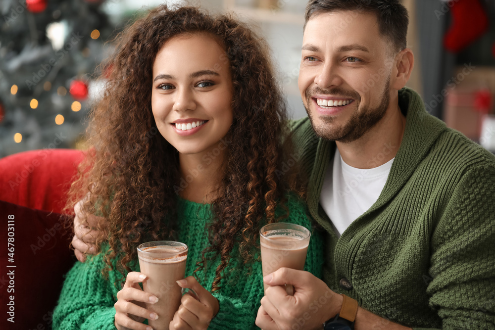 Happy couple drinking hot chocolate while celebrating Christmas at home