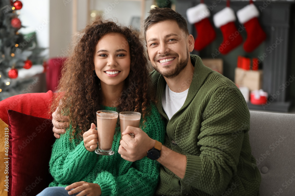 Happy couple drinking hot chocolate while celebrating Christmas at home