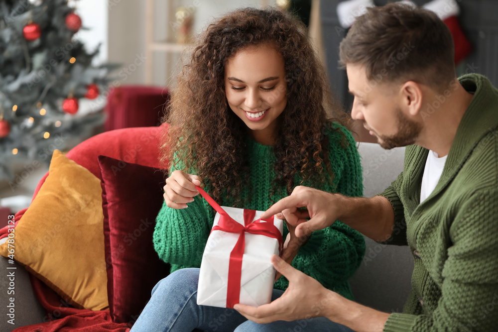 Happy couple with Christmas gift at home