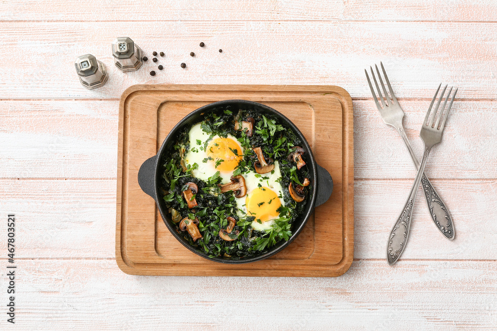 Frying pan with tasty Shakshouka on white wooden background