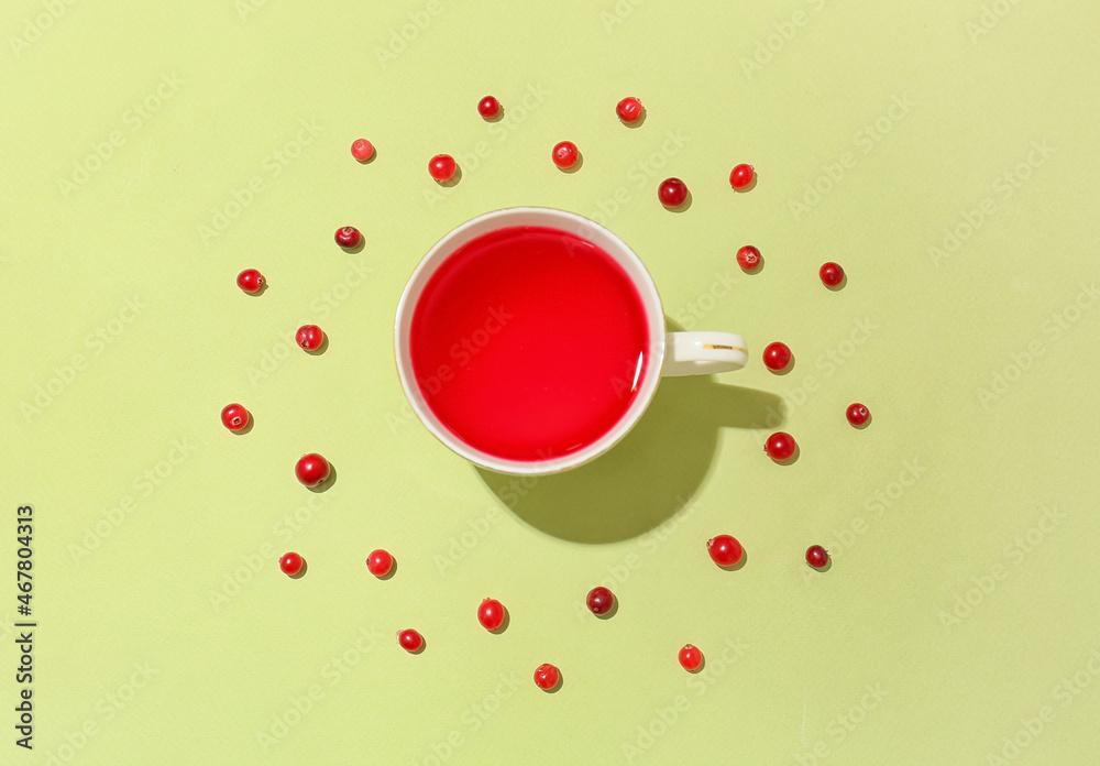 Composition with cup of tasty lingonberry tea and berries on color background