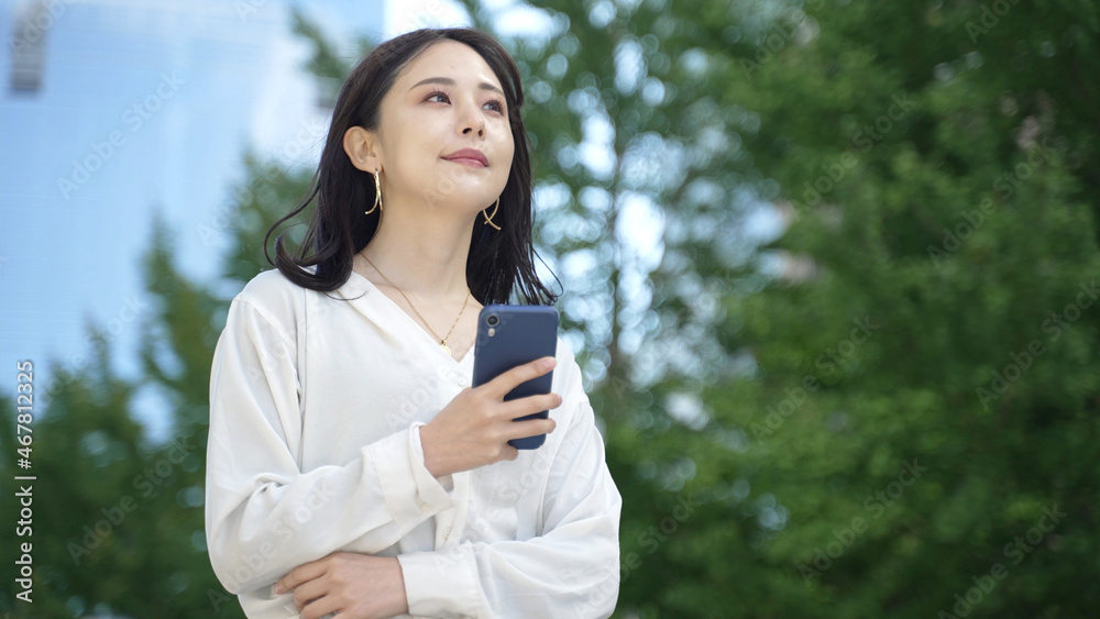 公園でスマートフォンを使う女性