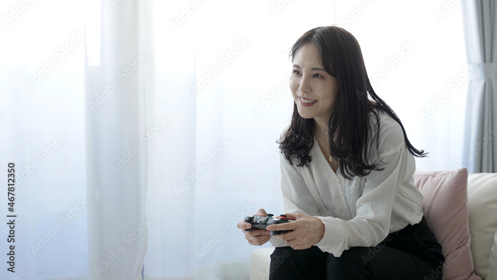 テレビゲームで遊ぶ女性