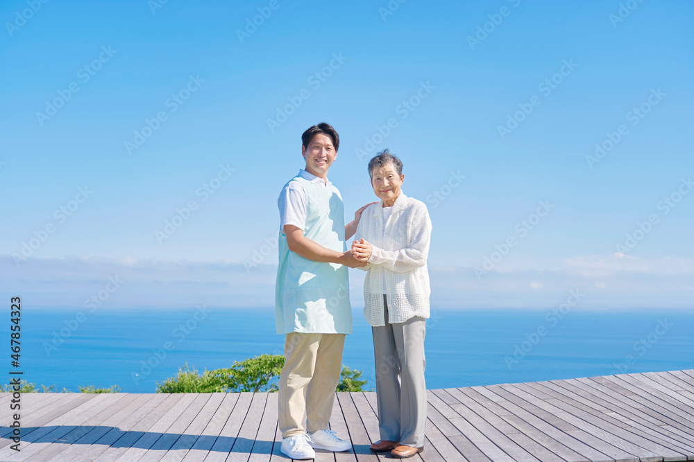 介護士と高齢者　屋外