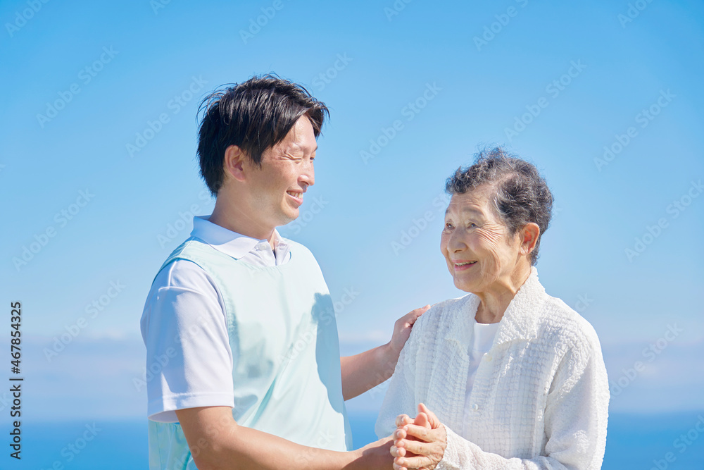 介護士と高齢者　屋外