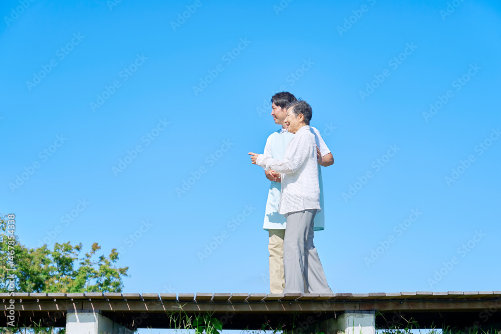 介護士と高齢者　屋外