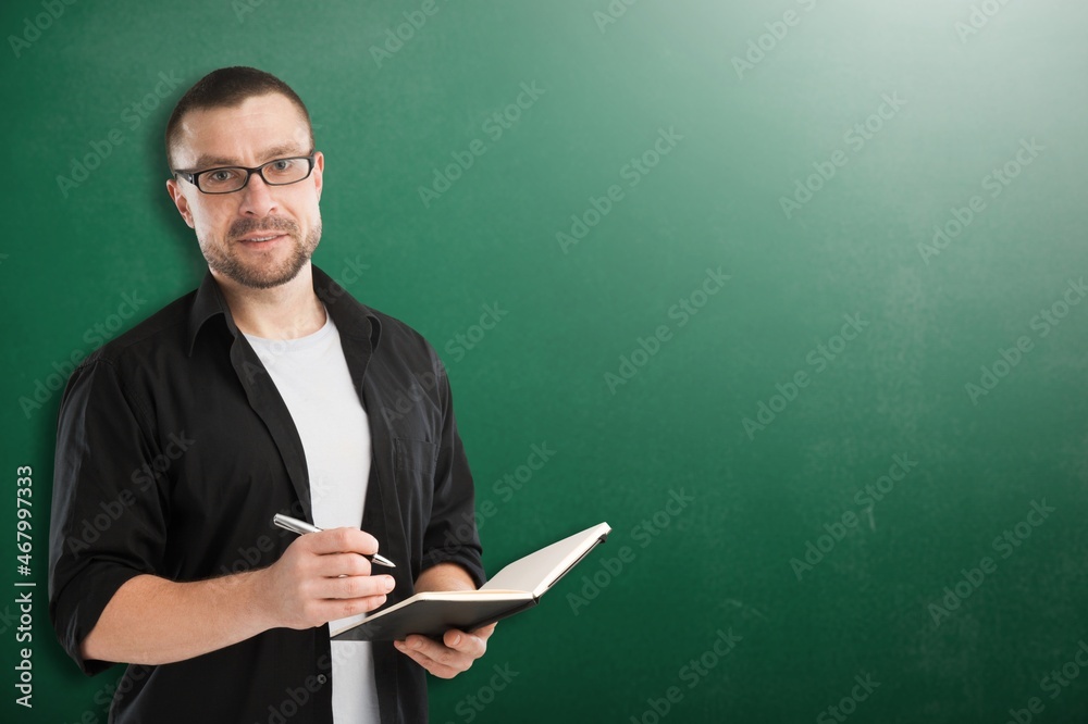 Young teacher man teaching holding book training the mathematics in classroom blackboard