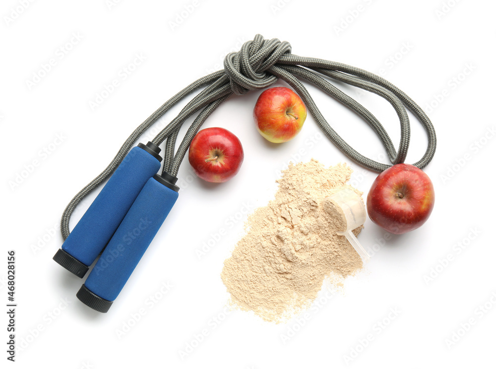 Scoop with protein powder, skipping rope and apples on white background