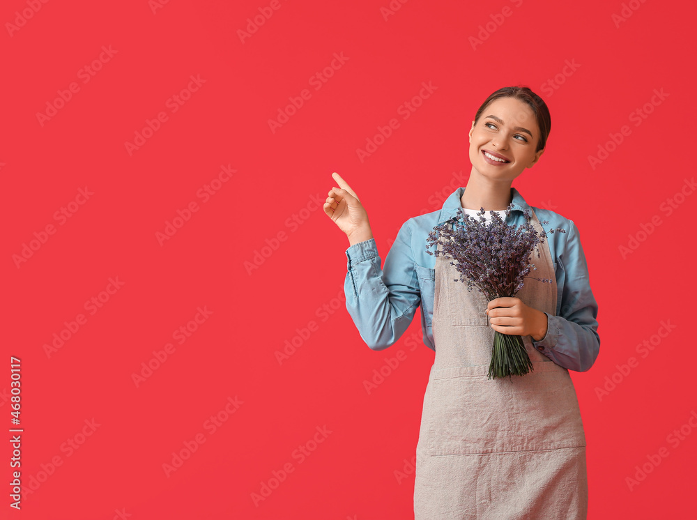 Female gardener with lavender pointing at something on color background