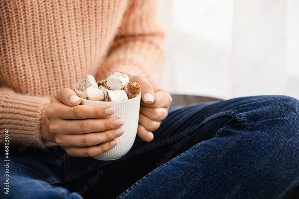 女人拿着一杯温热的可可和棉花糖，特写镜头