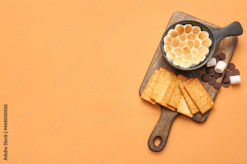 Frying pan with delicious Smores dip and crackers on color background