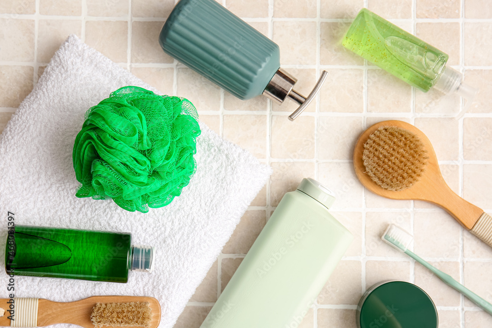 Set of different bath supplies on light tile, closeup