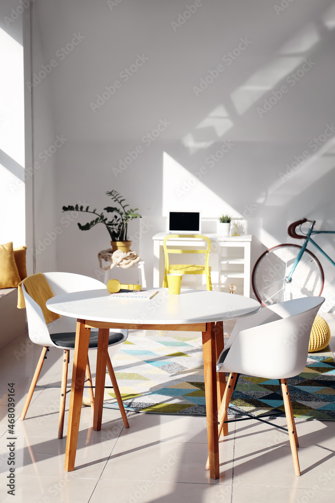 Dining table with headphones and cup in interior of light room