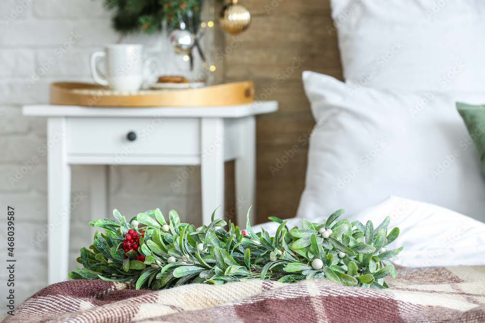 Beautiful mistletoe wreath on bed