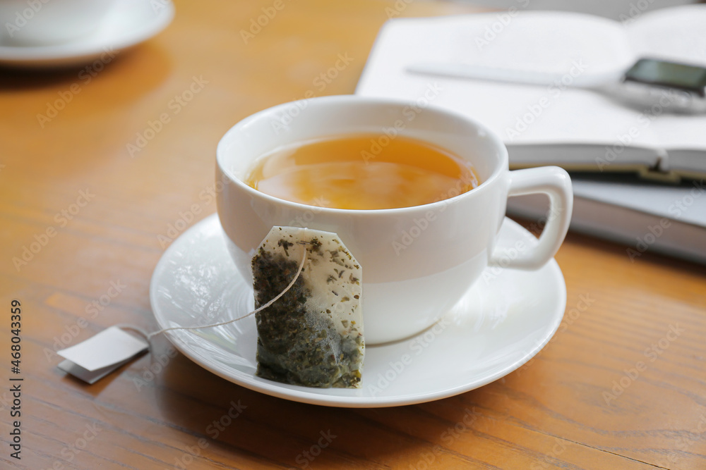 木桌上的茶包和一杯热饮料，特写