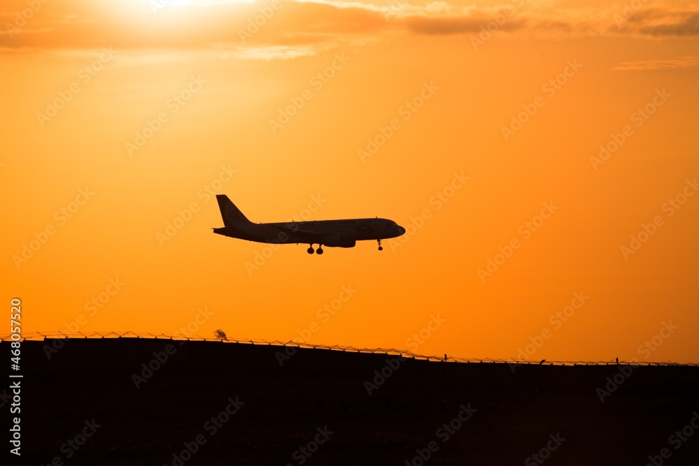 Amazing sunset and passenger plane flies and landing.