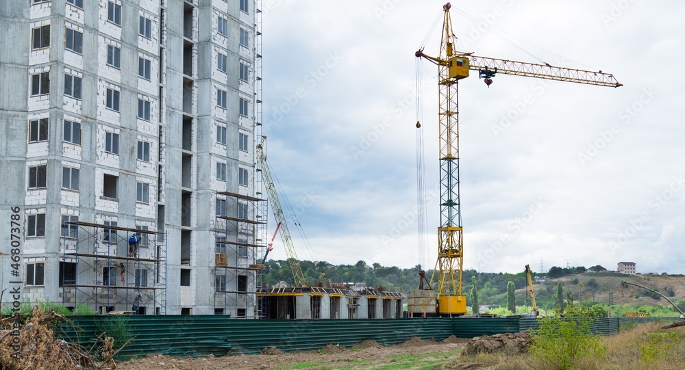 大型建筑工地，包括在建筑群上工作的几台起重机，天空晴朗