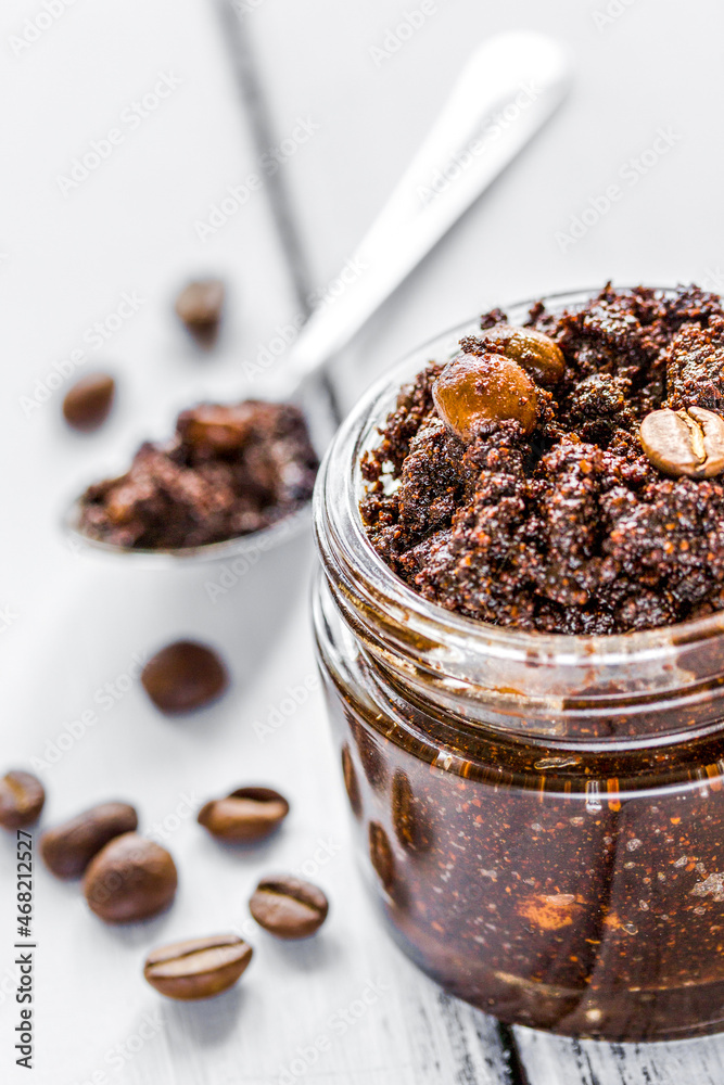 Homemade cosmetics with scrub and coffee beans on desk background