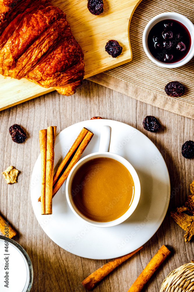 Breakfast with coffee and croissants on wooden table top view