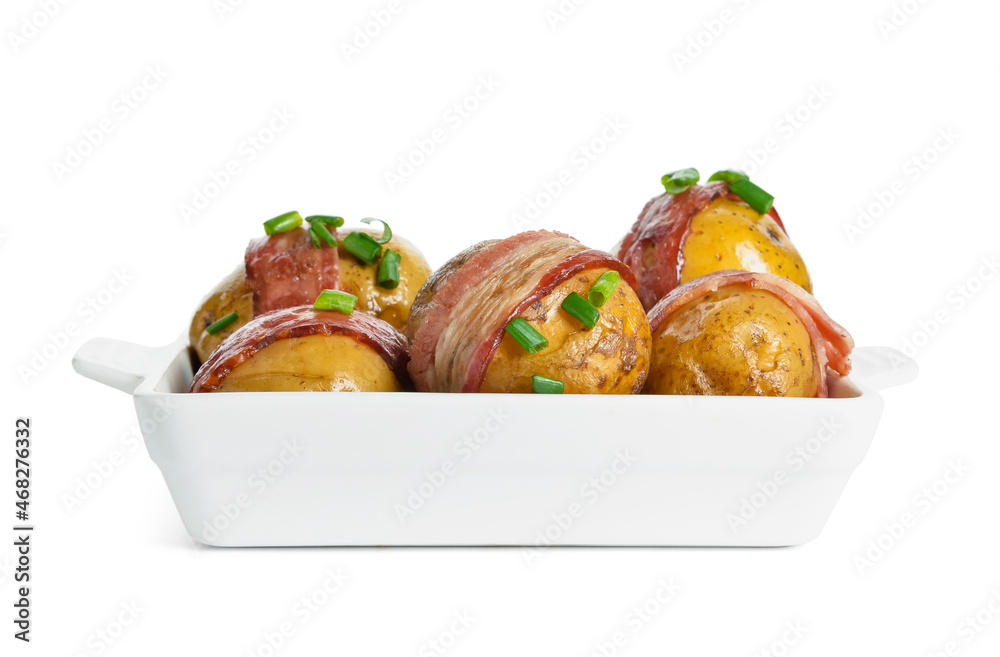 Baking dish of tasty baked potatoes with bacon on white background