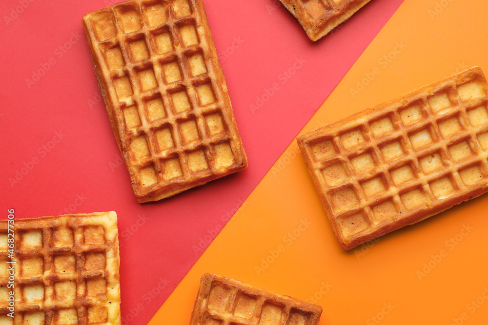 Yummy golden Belgian waffles on color background