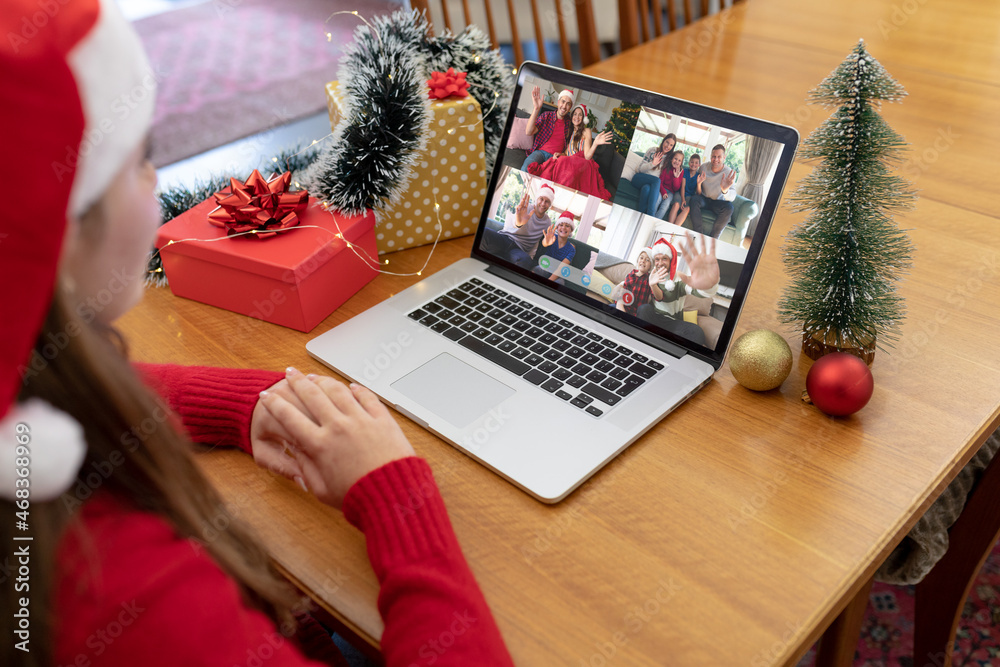 Caucasian woman in santa hat making christmas laptop group video call with family and friends