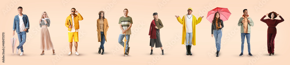 Group of stylish people in autumn clothes on light background