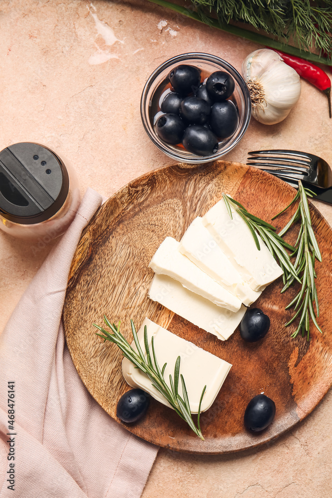 Plate with delicious feta cheese with rosemary and olives on color background