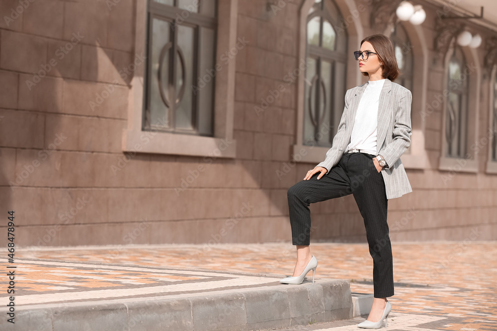 Young fashionable woman with stylish accessories on city street