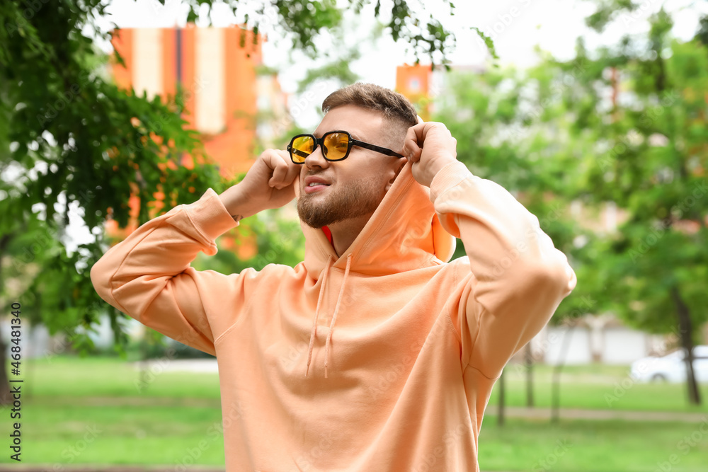 Young guy in stylish hoodie outdoors