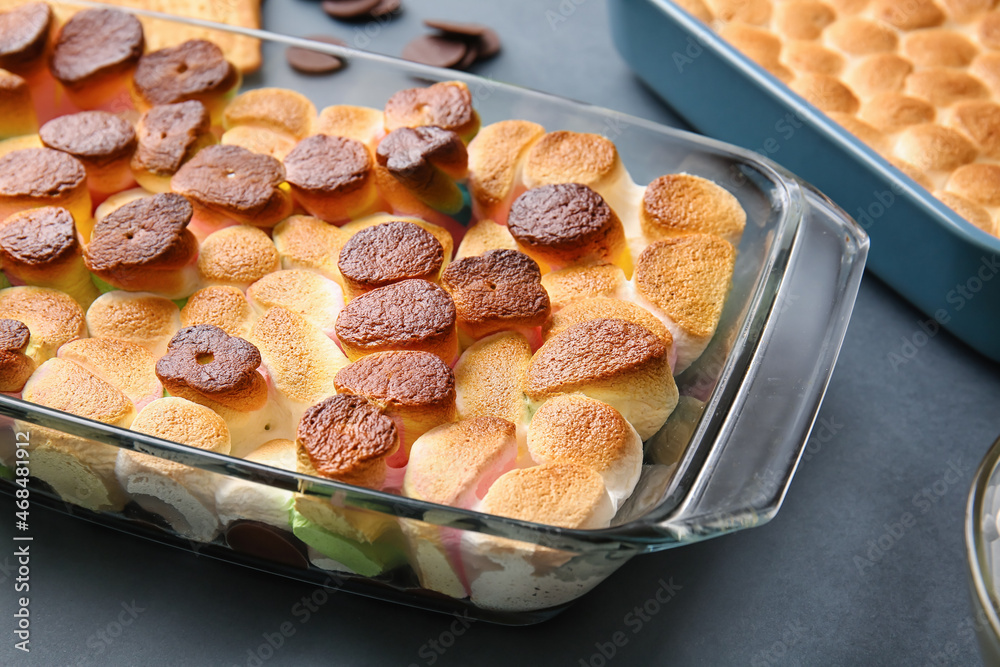 Baking dish with tasty Smores dip on dark background, closeup