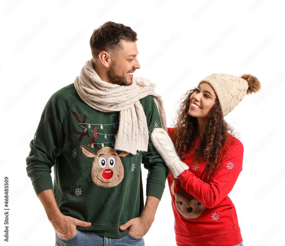 Happy couple in Christmas sweaters on white background