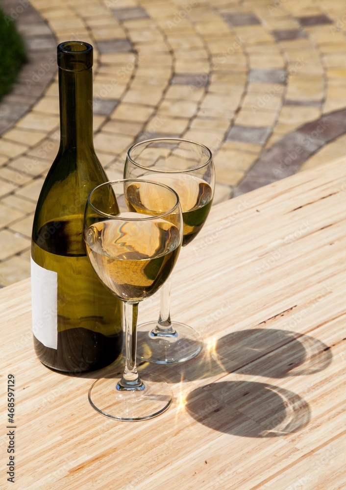 Bottle and glasses of white wine outdoors