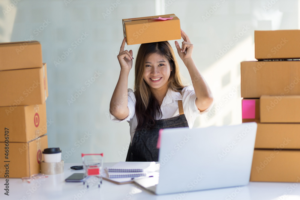 A pretty young woman who owns a small online business smiles happily.