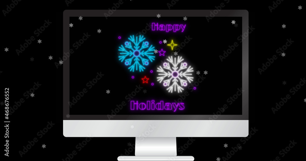 Image of happy holidays text on computer over snow falling on black background at christmas